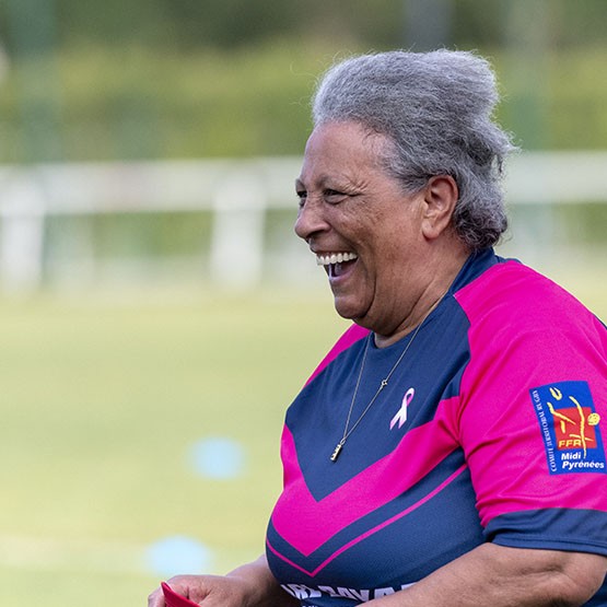 Senior participant smiling joyfully during a Rugby Santé session